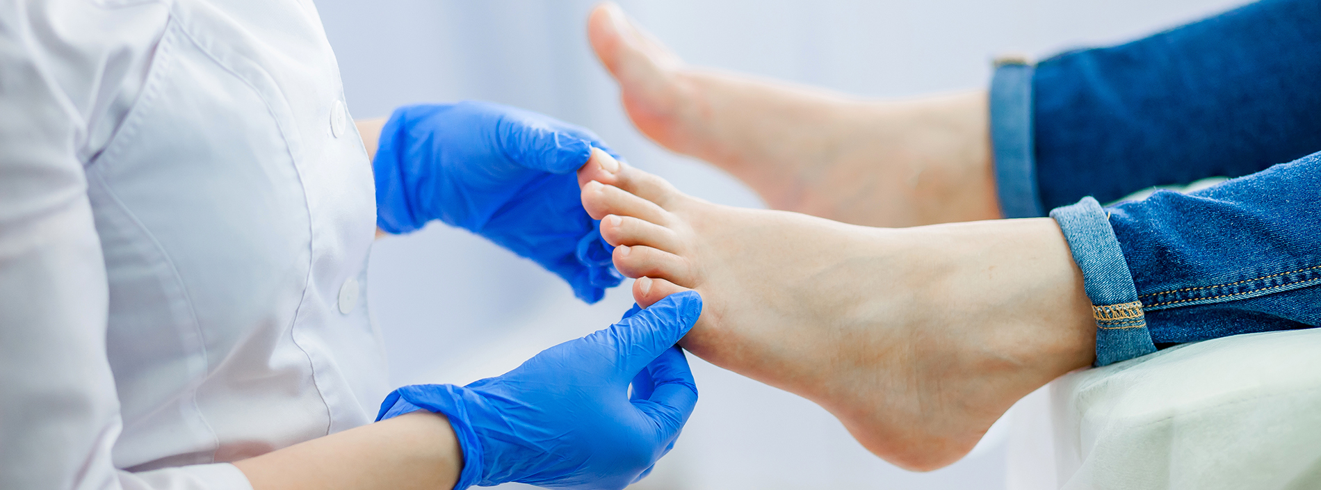 A person receiving a foot treatment by a professional in a medical setting.