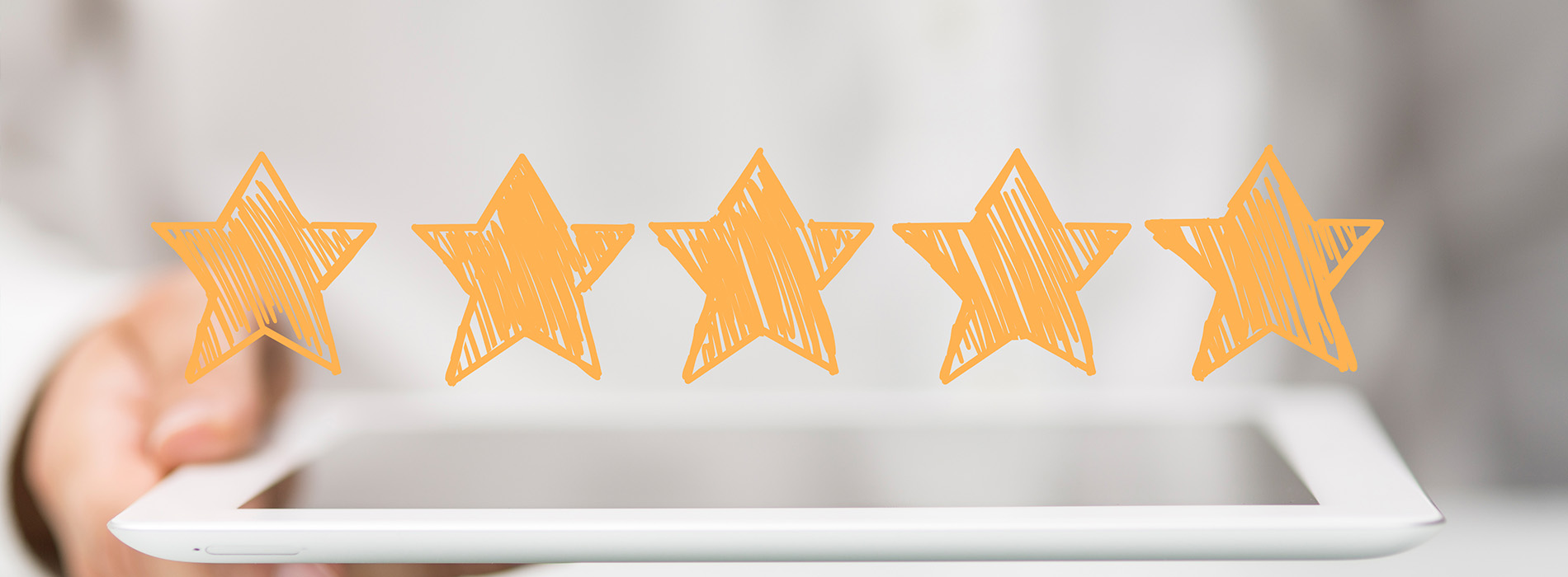 The image shows a hand holding a tablet displaying three yellow stars, suggesting a positive rating or review.